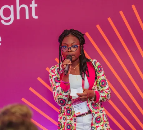 Woman speaking on the spotlight stage at the 2024 World Cancer Congress