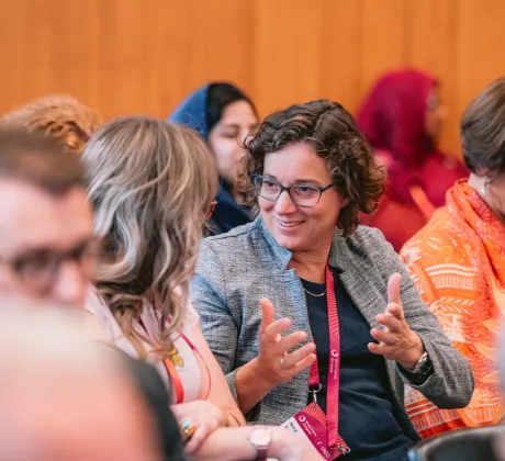 A woman smiling and speaking to a fellow congress participant