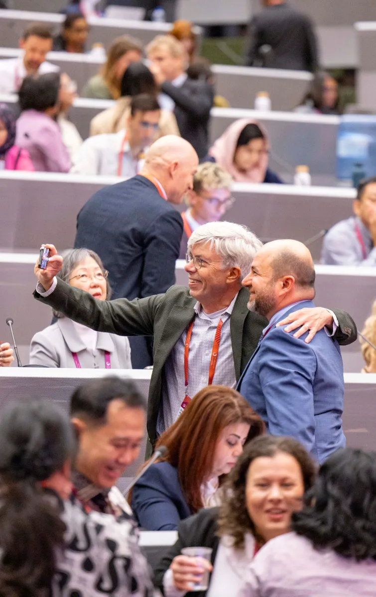Participants of a congress take a selfie together in the plenary